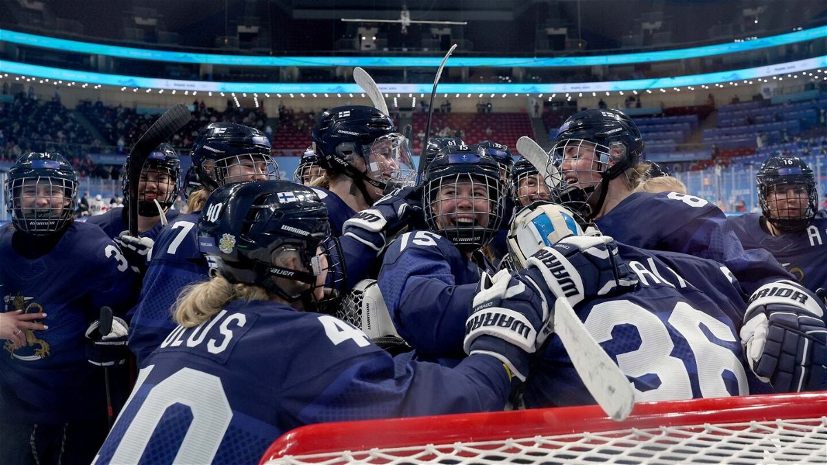 Finland women's hockey team players celebrate together on the ice