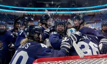 Finland women's hockey team players celebrate together on the ice