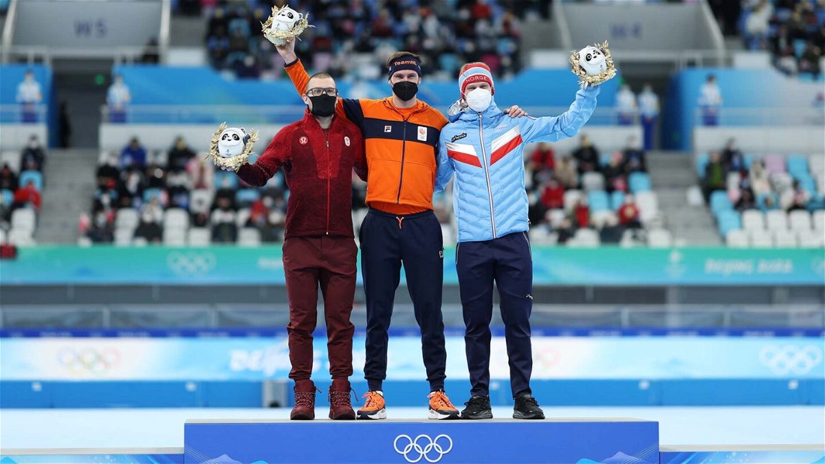 The three medalists stand on the podium together in celebration