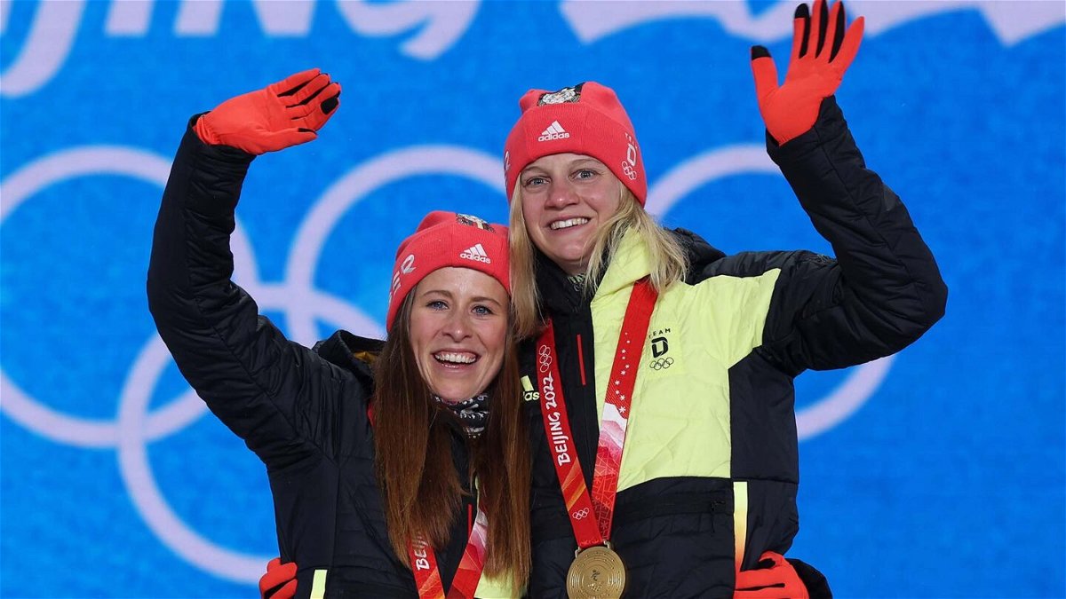 Katharina Hennig and Victoria Carl wave with Olympic gold medals around their necks
