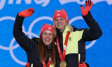 Katharina Hennig and Victoria Carl wave with Olympic gold medals around their necks