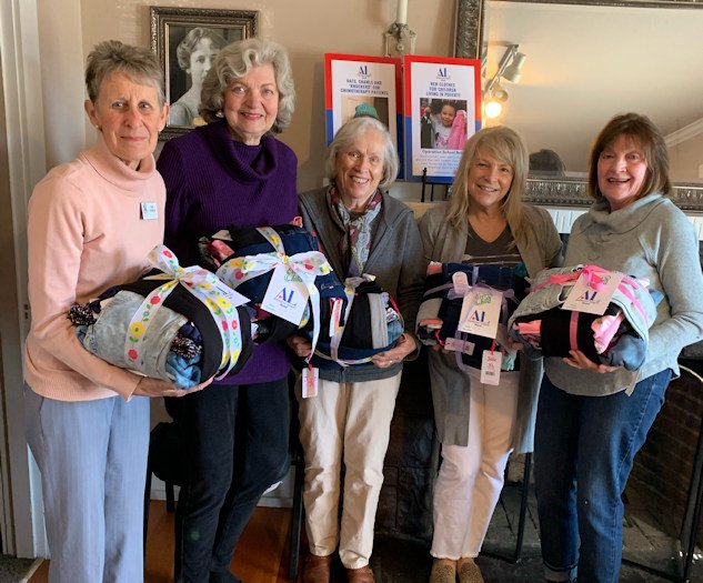 Sue Stanley, Carol Hastings, Patricia Reinhardt, Tamara Spain and Carla Gutman hold clothing bundles prepared for foster children
