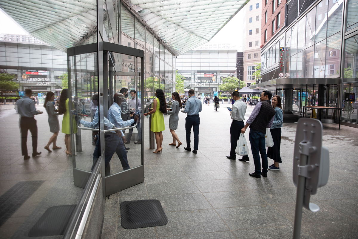 <i>Michael Nagle/Bloomberg/Getty Images</i><br/>New York City office workers wait in line to enter Goldman Sachs headquarters in June 2021. The company has required Covid-19 vaccination for entry since August 24