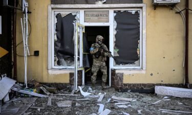 A Ukrainian serviceman exits a damaged building after shelling in Kyiv on March 12.