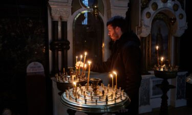 A man lights a candle in an Orthodox Church in Kyiv