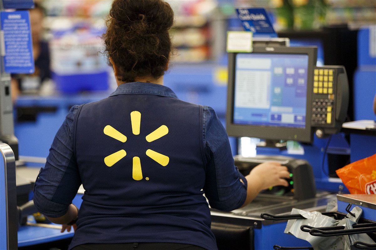 <i>Patrick T. Fallon/Bloomberg/Getty Images</i><br/>A Walmart employee scans items at a cash register in Burbank