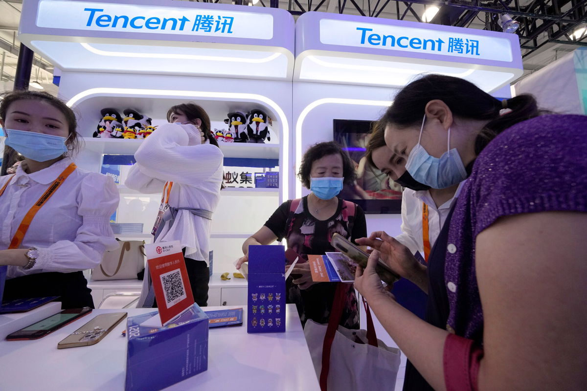 <i>Ng Han Guan/AP</i><br/>A woman is seen at the Tencent booth during a trade-in services fair in Beijing in September 2021. Stocks for the Chinese social media and gaming company Tencent