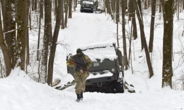 A Ukrainian soldier walks by destroyed Russian military vehicles in a forest outside Kharkiv on March 7.