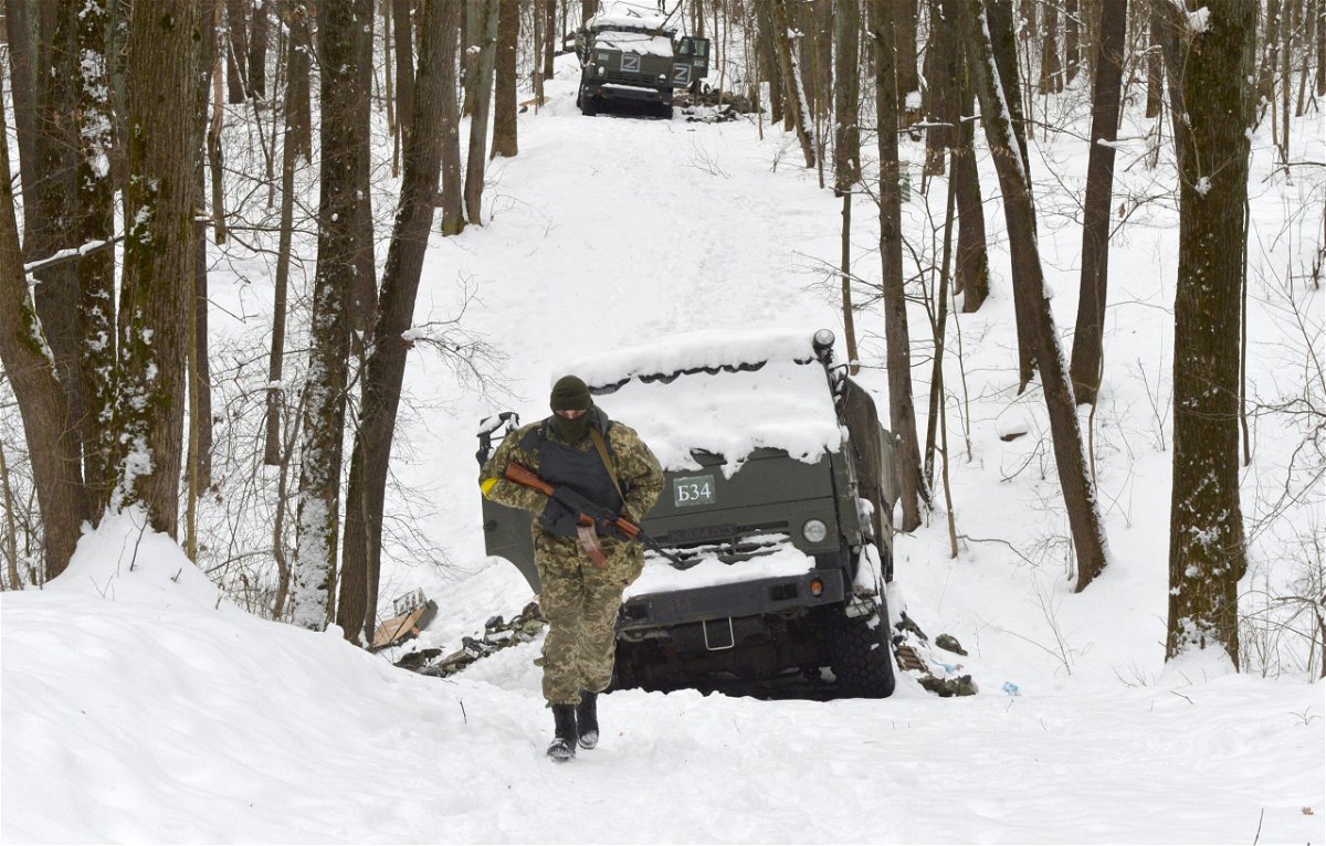 <i>Sergey Bobok/AFP/Getty Images</i><br/>A Ukrainian soldier walks by destroyed Russian military vehicles in a forest outside Kharkiv on March 7.