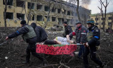 Ukrainian emergency employees and volunteers carry an injured pregnant woman from the damaged by shelling maternity hospital in Mariupol
