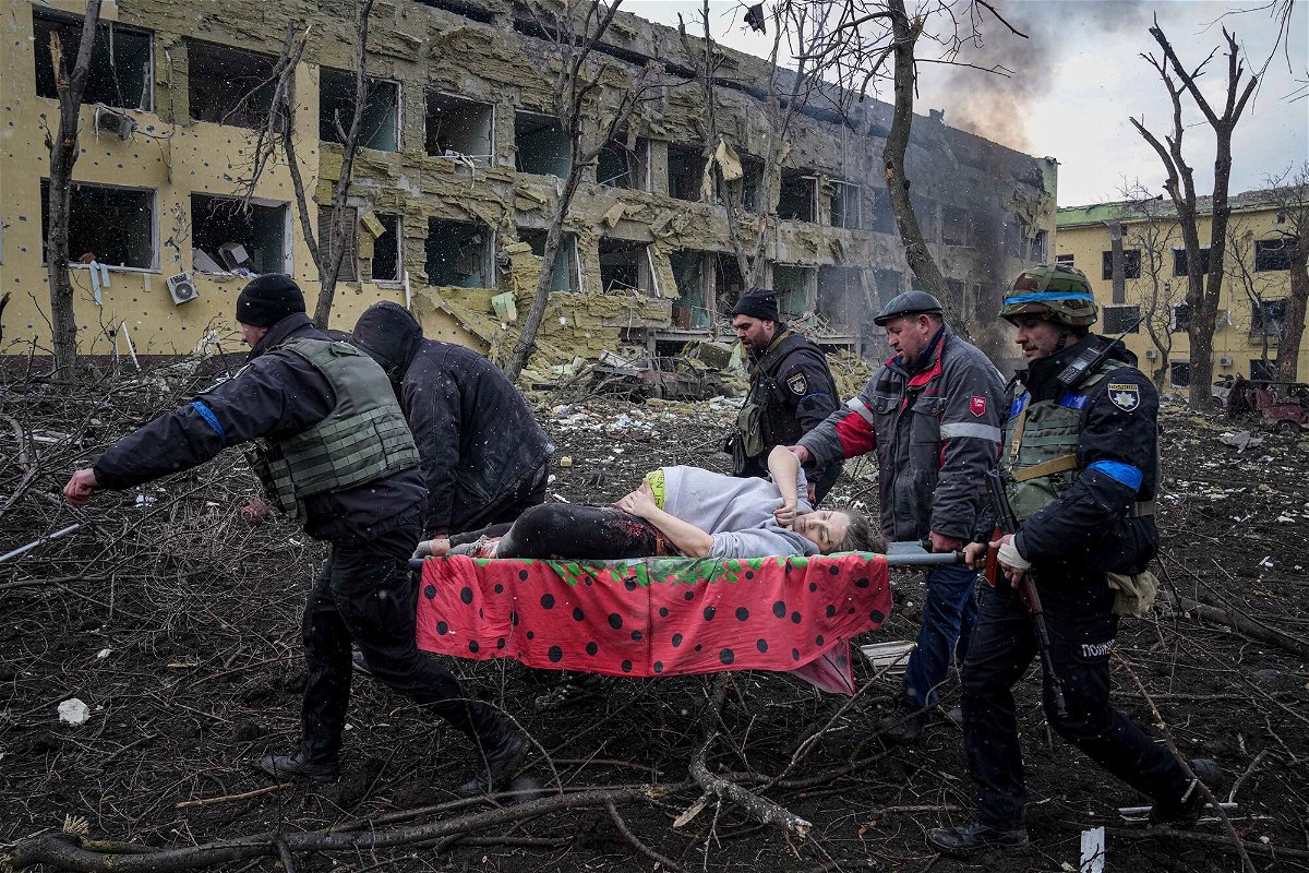 <i>Evgeniy Maloletka/AP</i><br/>Ukrainian emergency employees and volunteers carry an injured pregnant woman from the damaged by shelling maternity hospital in Mariupol