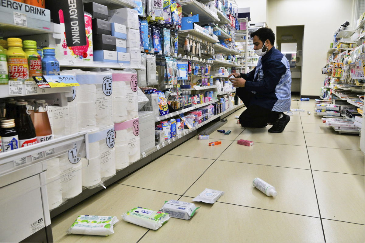 <i>Kyodo News/AP</i><br/>An employee clears products