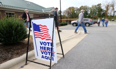 Voters arrive and depart a polling place on October 31