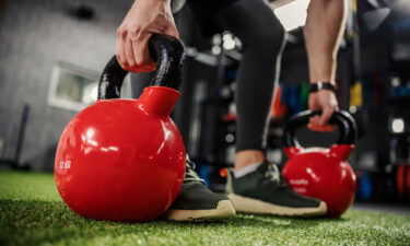 A person uses kettlebells for a strengthening exercise.