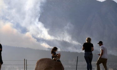 People watch as the NCAR Fire near Boulder burns in the foothills south of the National Center for Atmospheric Research on Saturday.