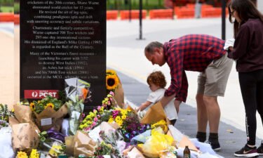 Flowers are placed at the base of a statue dedicated to Warne at the MCG.