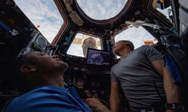 NASA engineers Thomas Marshburn (L) and Mark Vande Hei peer at the Earth from inside the International Space Station on February 4.