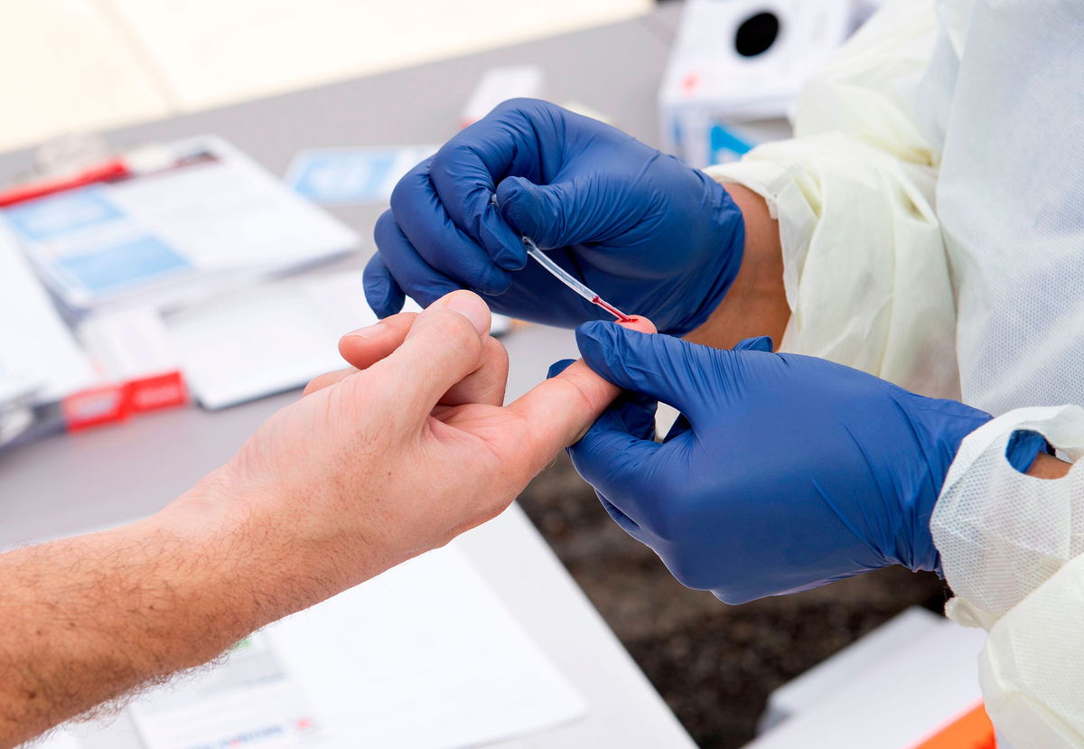 <i>Valerie Macon/AFP/Getty Images</i><br/>A health worker takes a drop of blood for the Covid-19 antibody test in Torrance