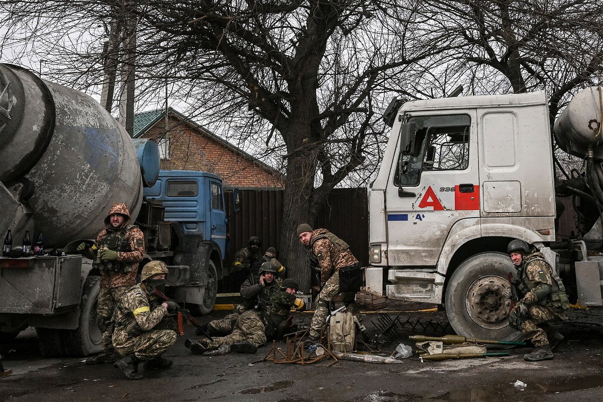 <i>Aris Messinis/AFP/Getty Images</i><br/>Ukainian service men take cover from shelling in the city of Bucha