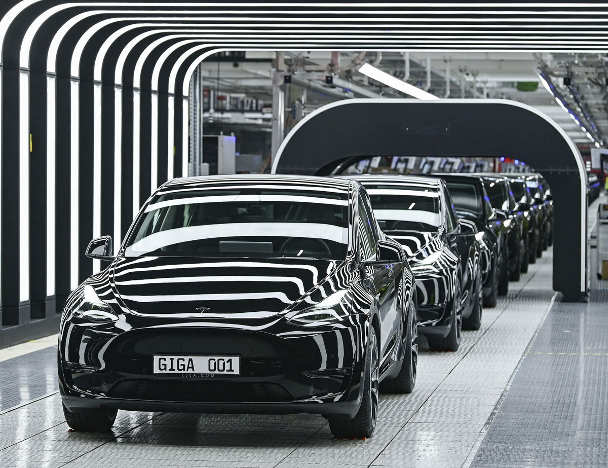 <i>Patrick Pleul/dpa-Zentralbild/Pool/AP</i><br/>Model Y electric vehicles stand on a conveyor belt at the opening of the Tesla factory near Berlin earlier this month.