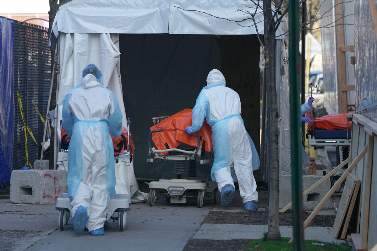 <i>Bryan R. Smith/AFP/Getty Images</i><br/>Bodies are moved to a refrigerator truck serving as a temporary morgue in New York. The global Covid-19 death toll surpassed 6 million on March 7