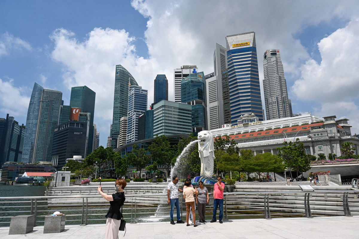 <i>ROSLAN RAHMAN/AFP/Getty Images</i><br/>People take pictures in front of the Merlion statue in Singapore on March 24.