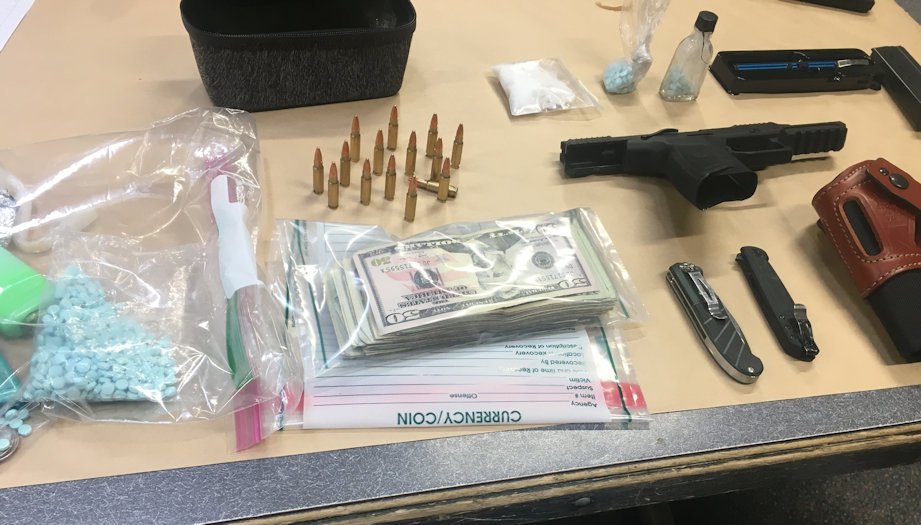 Drug agents displayed counterfeit pills, cash and weapons seized from Prineville drug trafficking suspect