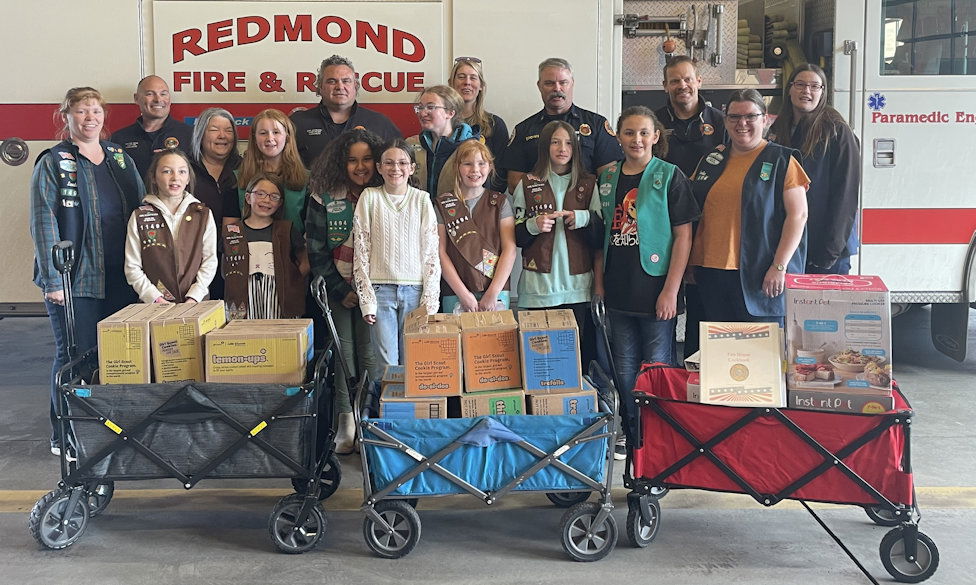 Redmond Girl Scouts Troop 11494 poses with Redmond firefighters and the gifts they brought