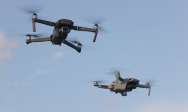 A DJI Mavic 2 Pro and DJi Mavic Mini made by the Chinese drone maker fly near each other on December 15