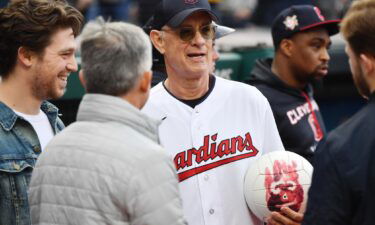 Actor Tom Hanks holds Wilson the volleyball from his film Cast Away before the game between the Cleveland Guardians and the San Francisco Giants at Progressive Field.