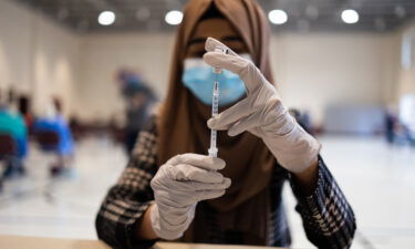 A healthcare worker prepares a dose of a Covid-19 booster shot at a vaccine clinic in Lansdale