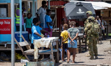 Australian Army soldiers talk with locals during a community engagement patrol through Honiara on November 27