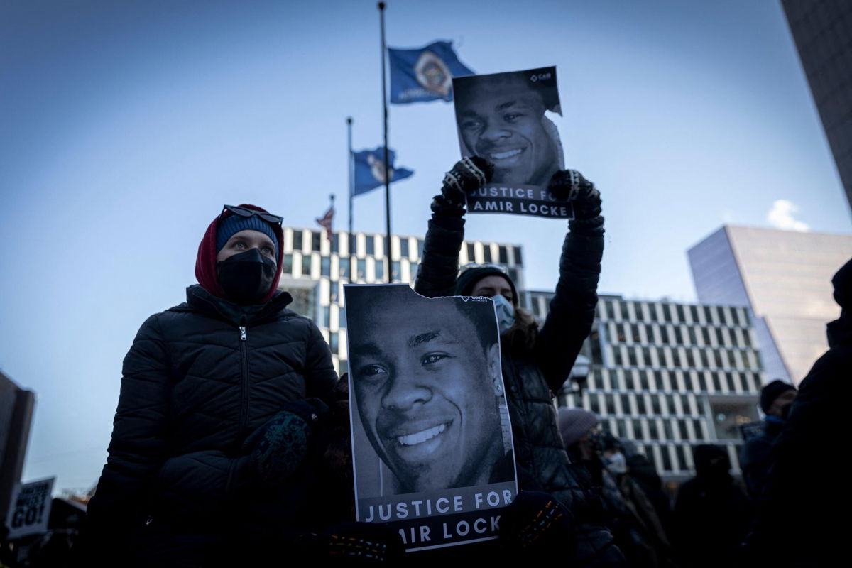 <i>KEREM YUCEL/AFP/Getty Images</i><br/>Demonstrators hold photos of Amir Locke during a rally in protest of his killing