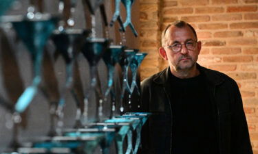 Ukrainian artist Pavlo Makov poses by his piece 'Fountain of Exhaustion' at Ukraine's pavilion during a press day at the 59th Venice Art Biennale in Venice on April 19.