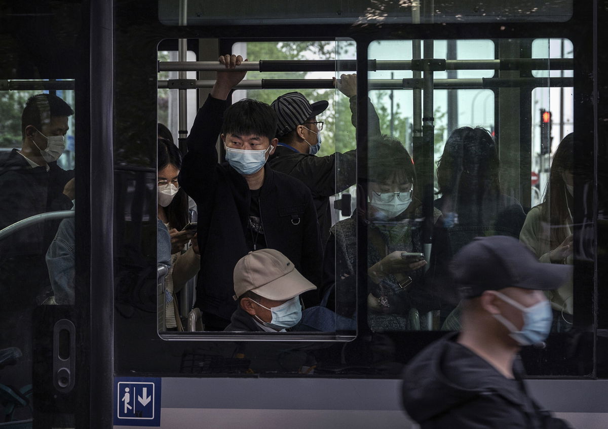 <i>Kevin Frayer/Getty Images</i><br/>People wear protective masks as they ride on a public bus during evening rush hour  in the Central Business District on April 21