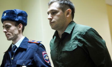 Police officers escort Trevor Reed into a courtroom before a March 2020 hearing in Moscow. A Russian court on April 12 remanded the case of Reed