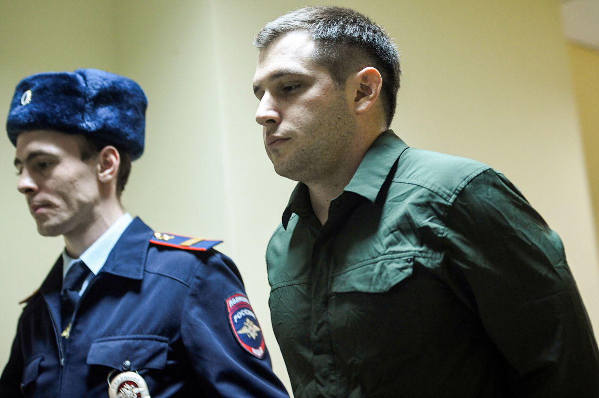 <i>ALEXANDER NEMENOV/AFP/Getty Images</i><br/>Police officers escort Trevor Reed into a courtroom before a March 2020 hearing in Moscow. A Russian court on April 12 remanded the case of Reed