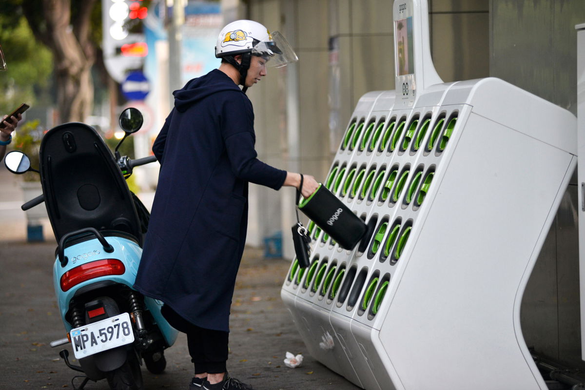 <i>CHRIS STOWERS/AFP/Getty Images</i><br/>A rider swapping batteries at a Gogoro GoStation in Taipei in 2018. Gogoro