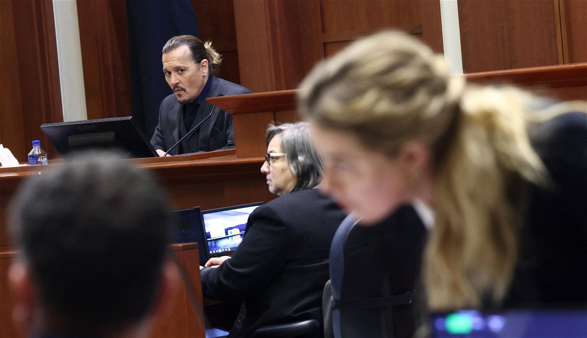 <i>Jim Lo Scalzo/AFP/Pool/AFP via Getty Images</i><br/>Amber Heard speaks to her legal team as Johnny Depp is on the stand in their defamation trial.