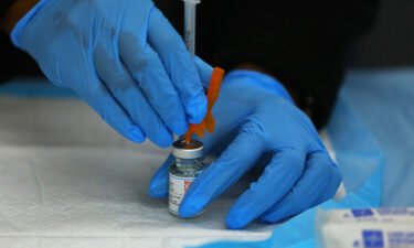 A dose of the Moderna COVID-19 Vaccine is prepared at a COVID-19 testing and vaccination site in Boston.