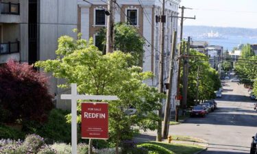A "For Sale" sign is posted outside a residential home in the Queen Anne neighborhood of Seattle