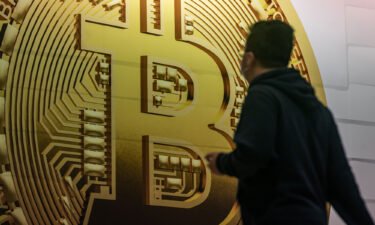 Some 401(k)s will soon let you invest in crypto. Pedestrians are seen walking past an advertisement displaying a Bitcoin cryptocurrency token on February 15 in Hong Kong