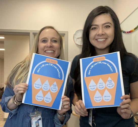 Caldera counselors Jess Calbreath and Lesley Zavala hold up posters for the school’s Wellness Week, which ask students and staff “How will you fill your bucket?”