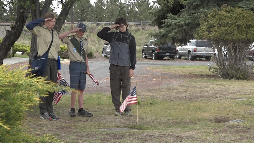 Scouts honor veterans by placing American flags on graves at Bend cemetery