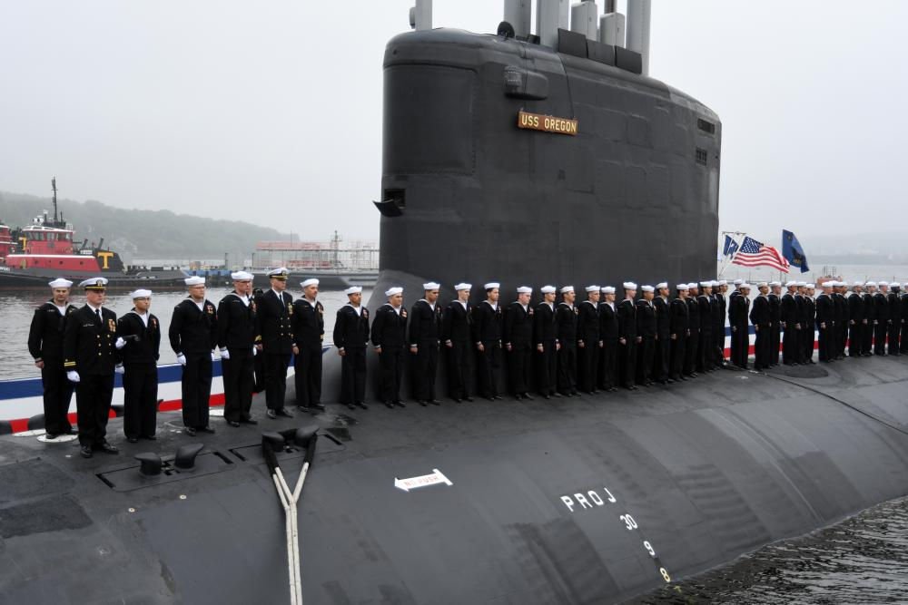 Crewmembers attached to the Virginia-class fast attack submarine USS Oregon (SSN 793) man the ship Saturday during a commissioning ceremony in Groton, Conn.