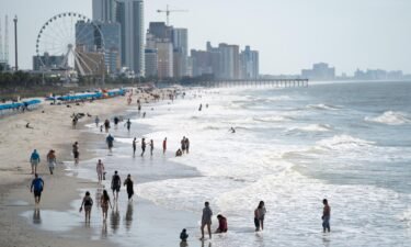 People walk along the beach the morning of May 29 in Myrtle Beach