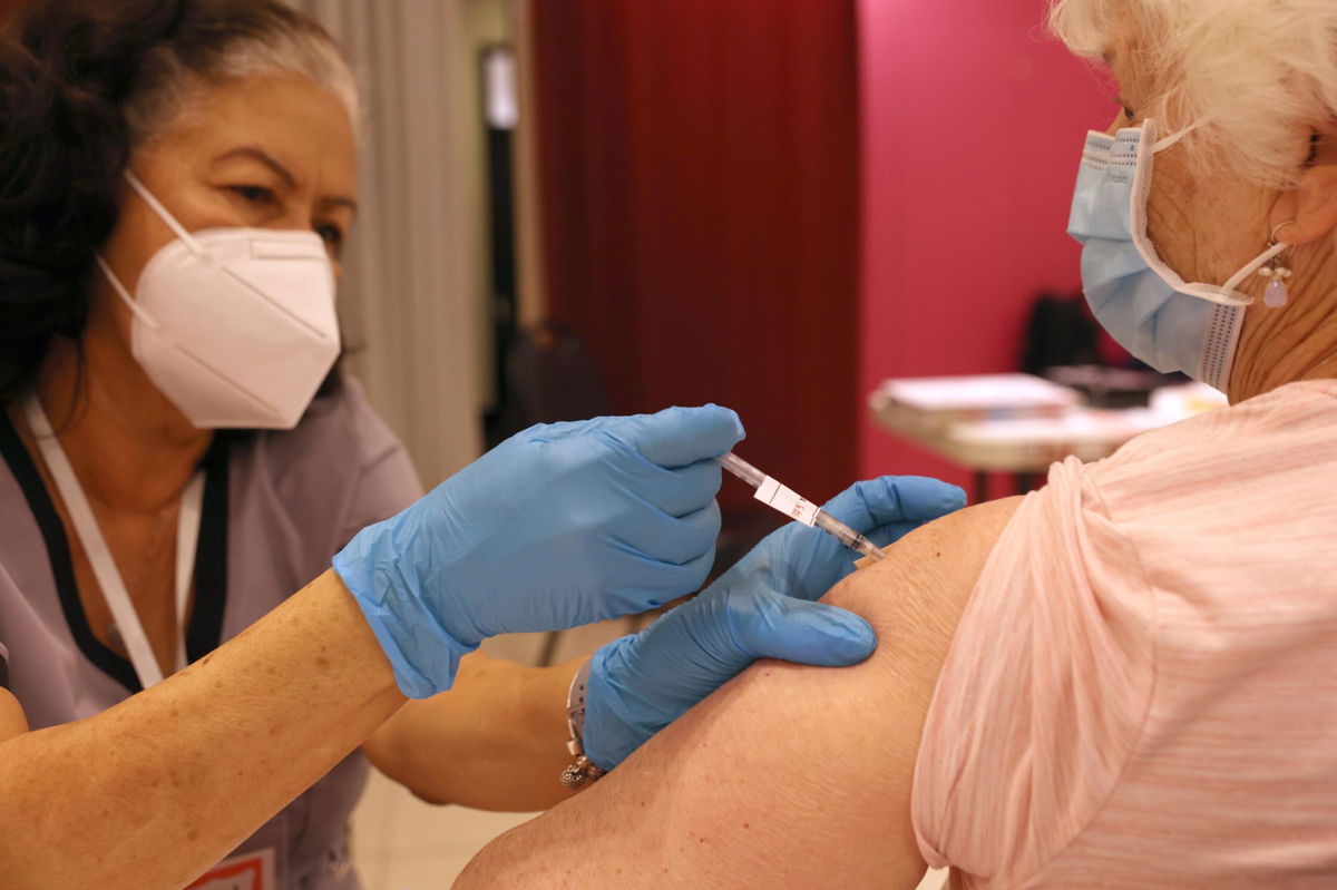 <i>Justin Sullivan/Getty Images</i><br/>Registered Nurse Orlyn Grace (L) administers a COVID-19 booster vaccination to Jeanie Merriman (R) at a COVID-19 vaccination clinic on April 06 in San Rafael