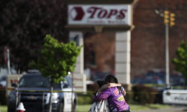 People hug near the scene of the mass shooting at the Tops Friendly Markets store on May 14.