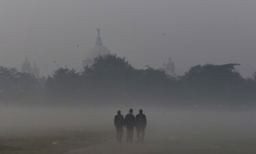 People walks through the dense smog in Kolkata