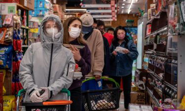 People wait in long lines at a supermarket on May 12 in Beijing